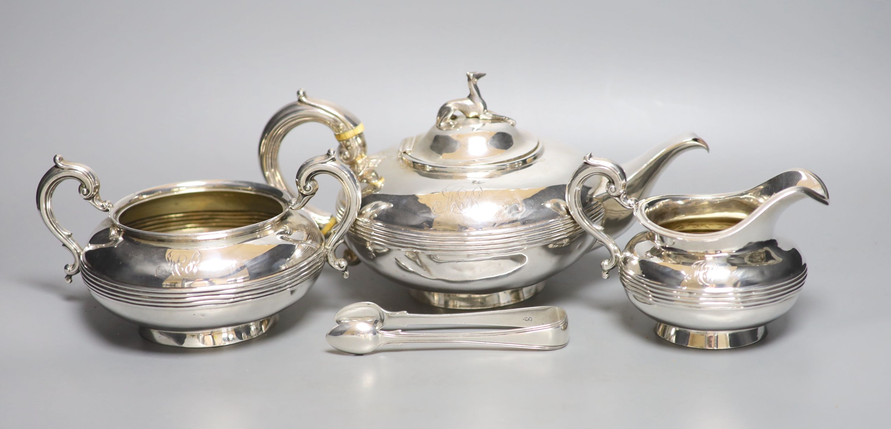 A Victorian silver three piece silver tea set, William Smily, London, 1856 and a pair of earlier silver sugar tongs, gross weight 40 oz.